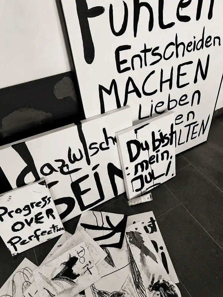 Verschiedene handgefertigte Schilder mit inspirierenden Zitaten in Schwarz-Weiß.