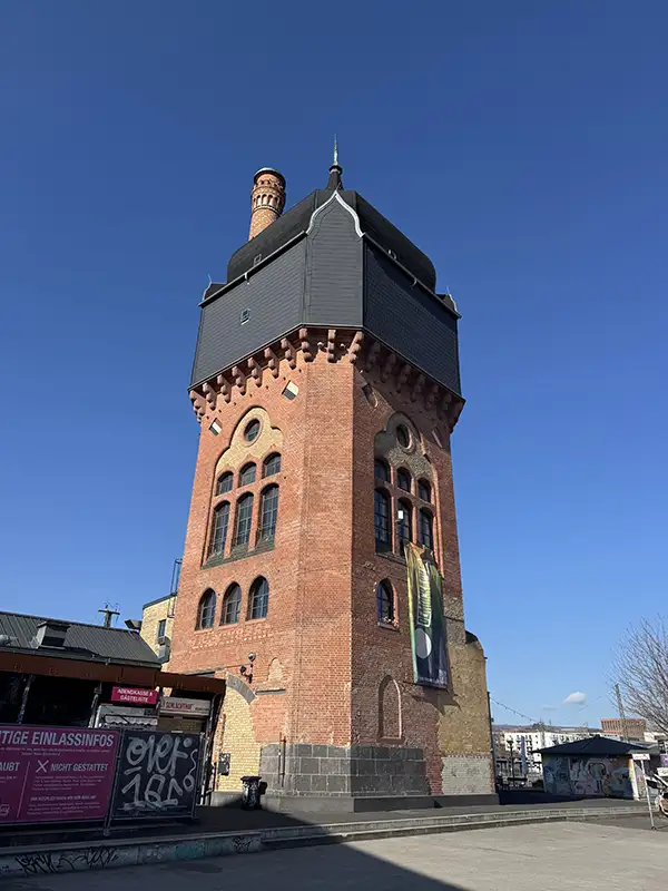 Großes altes Turmgebäude aus rotem Sandstein und hohen Fenstern an einer Straße