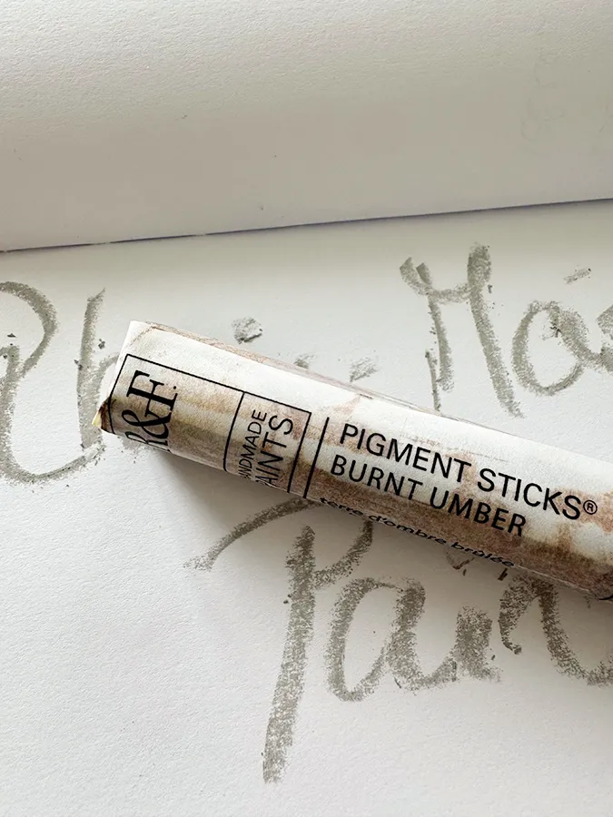Detailansicht eines hellen Pastellkreidestifts auf Papierblock